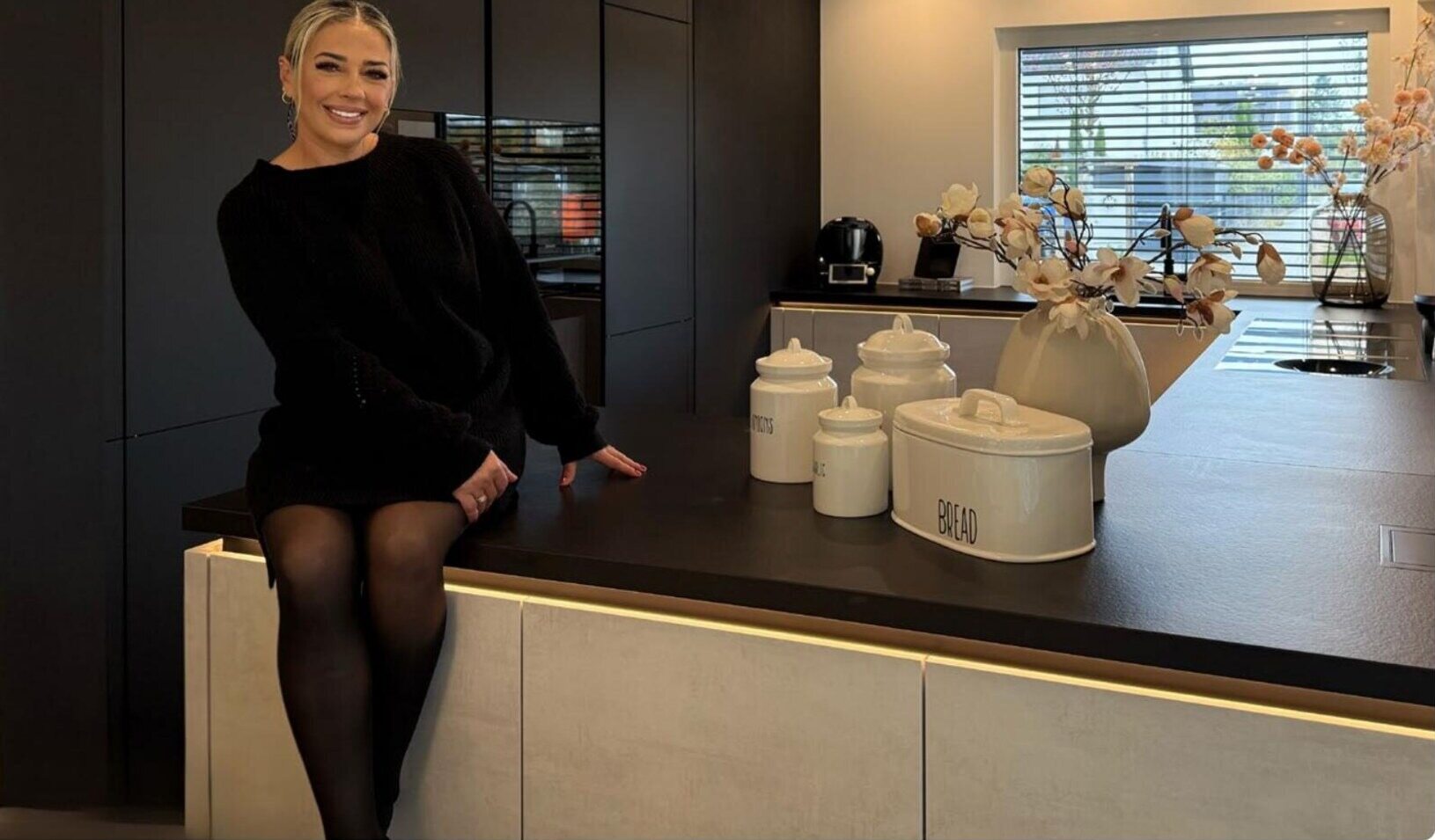 Zeynep in ihrer Küche mit Fenster und Raffstore im Hintergrund